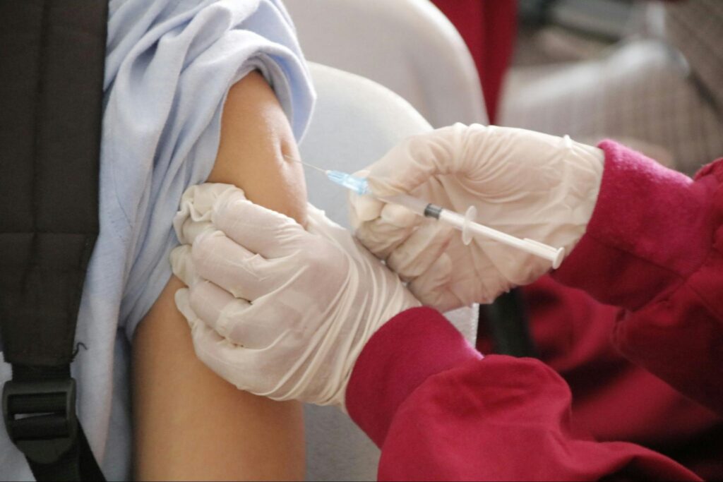 Enfant recevant un vaccin par une infirmière pour préparer la rentrée